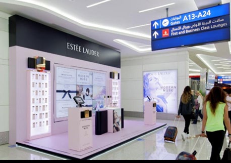 Estée Lauder retail counter with digital screens in an airport terminal